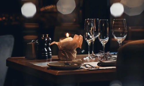 wine glasses and a candle in a warm lit restaurant