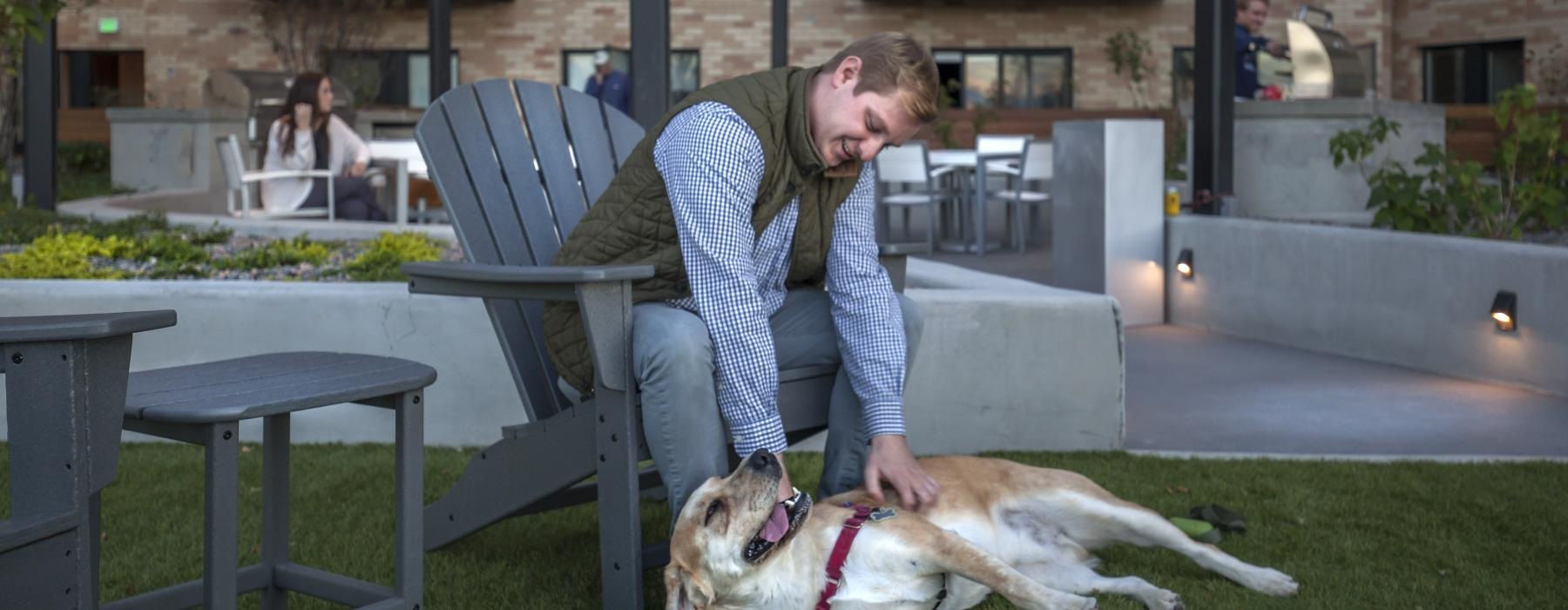 a person and a dog sitting on a bench outside