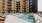 a pool in a courtyard with buildings in the background