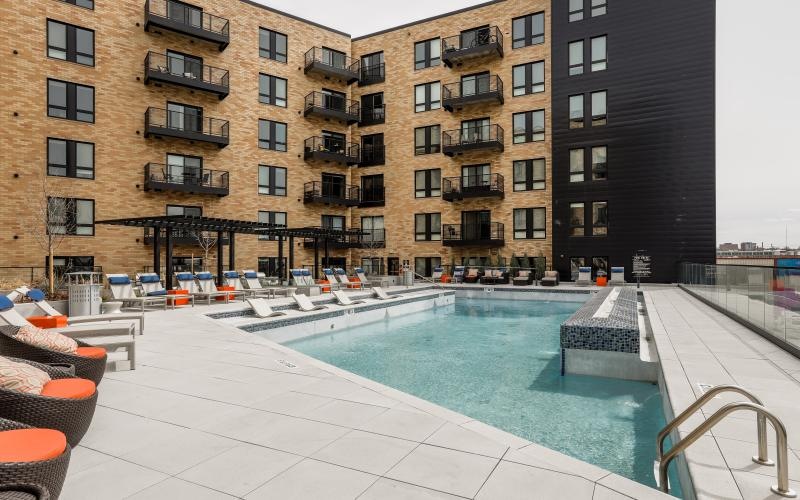 a pool in a courtyard with buildings in the background